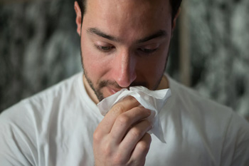 Man blowing into tissue